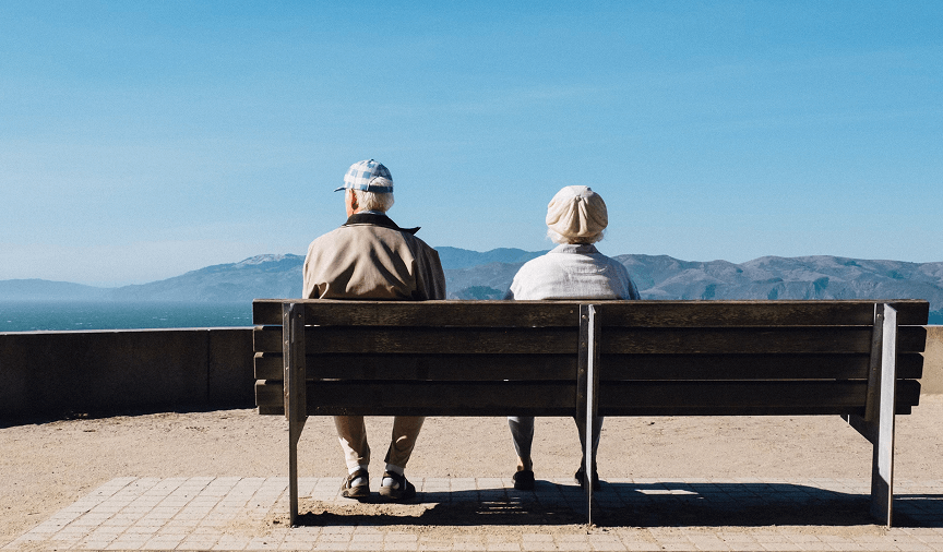 two elderly people sitting on a bench
