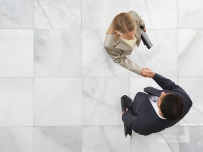 Top view of a businessman and woman shaking hands in office lobby
