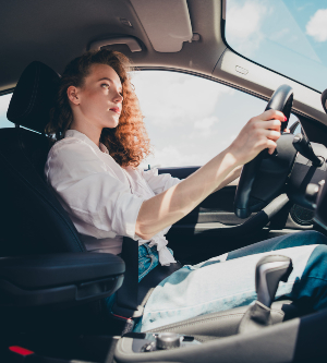 Imagen de una mujer joven conduciendo un automóvil en la ciudad retrato de una hermosa mujer en un automóvil mirando por la ventana y sonriendo
