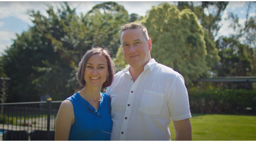 Man and woman arm in arm smiling to the camera