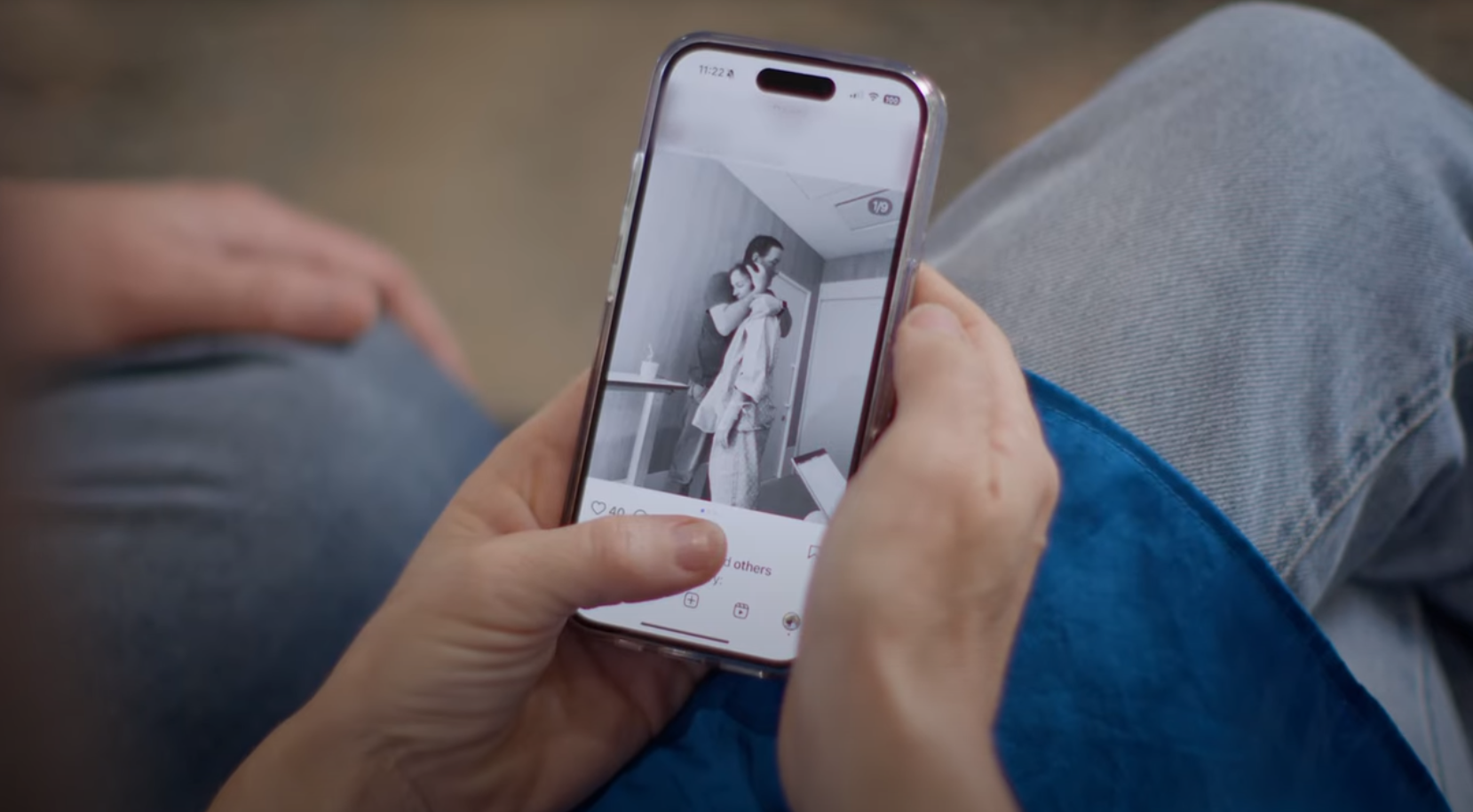 Image of mobile phone with an instragram picture of a woman in a hospital gown leaning on her husband