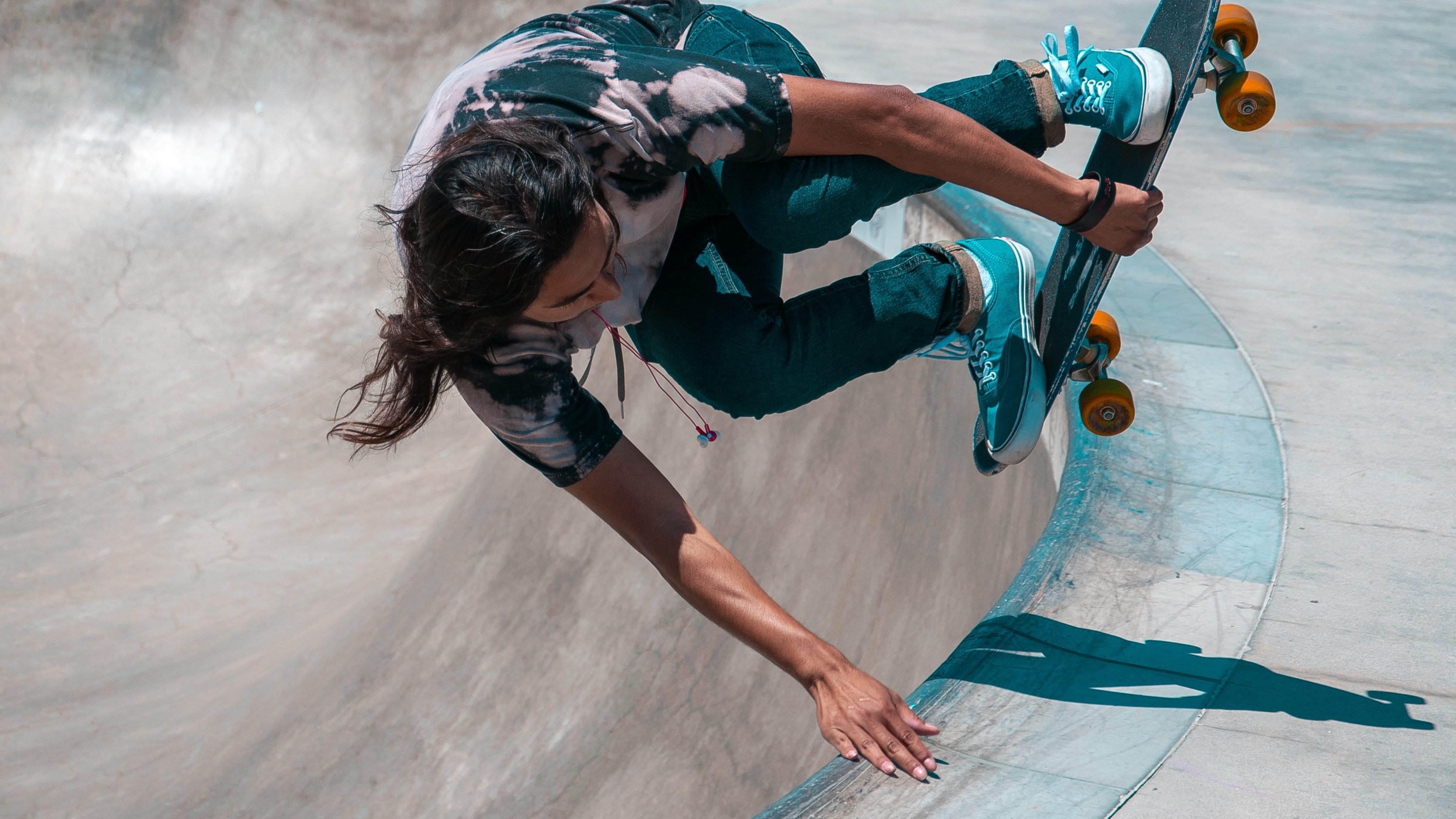 Person on a skateboard in a skate bowl doing a trick