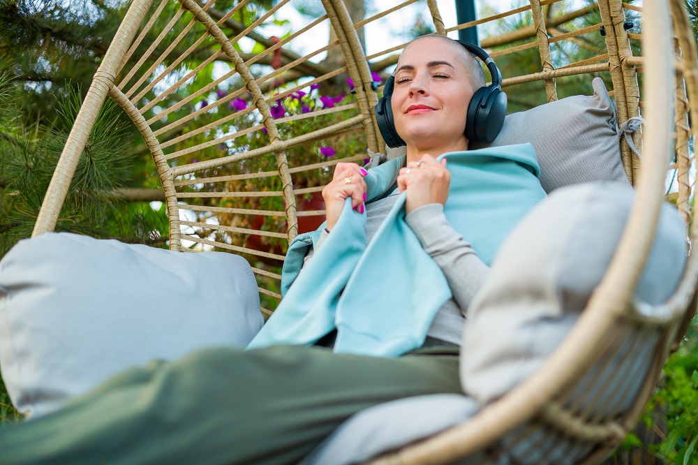 Jeune femme souriante assise dans un fauteuil avec un casque audio