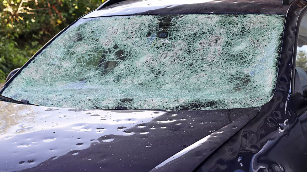 Stark durch Hagel zerstörte Heckscheibe eines Autos