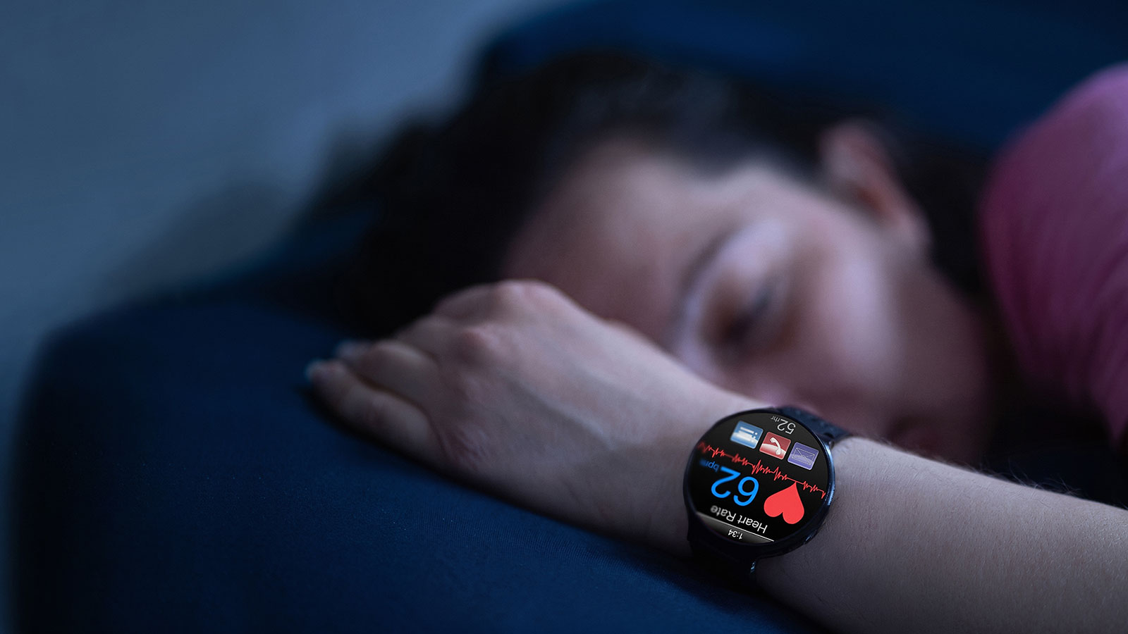 Sleeping person wearing a smartwatch that monitors heart rate and health data during the night.