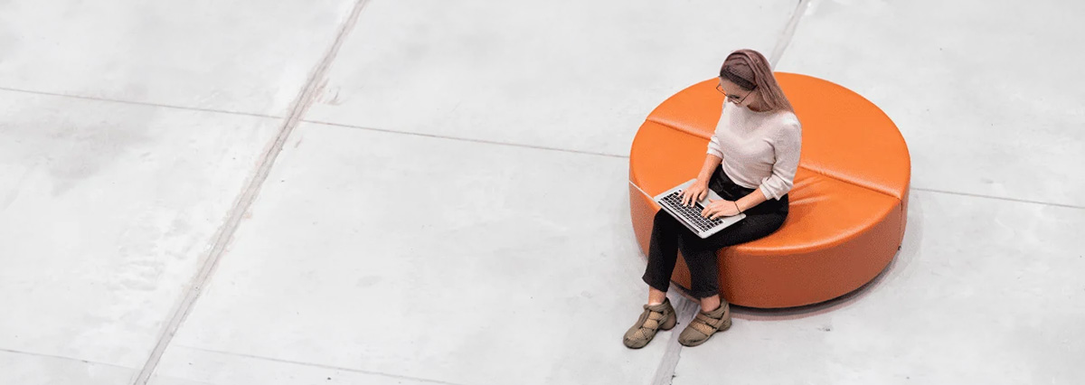 a woman is working on a laptop on a couch