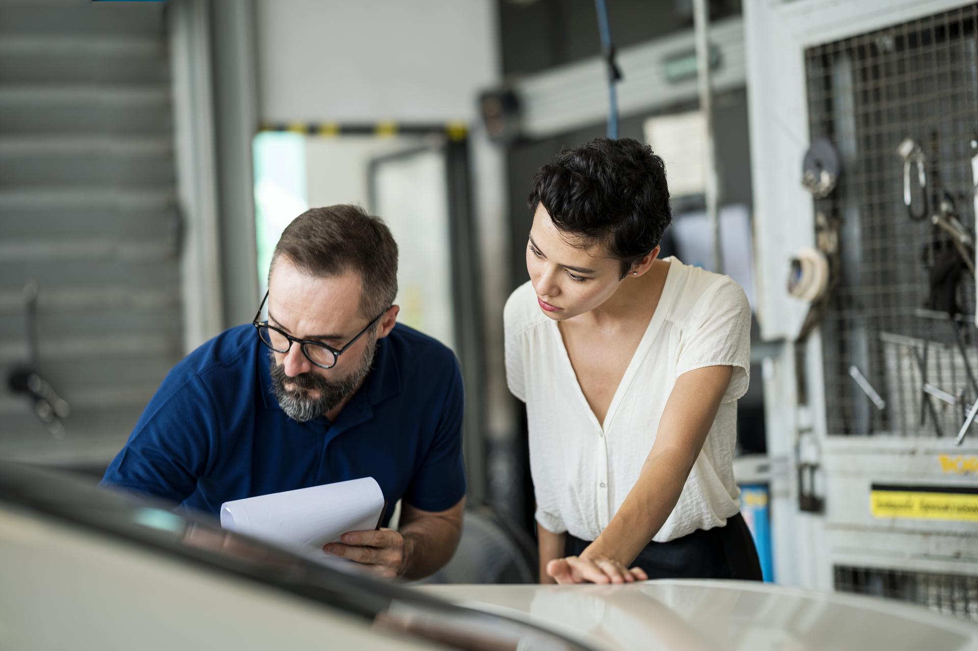 co-workers looking at paper together