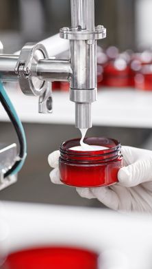 Photo of a person using a machine that is pouring a substance on a recipient