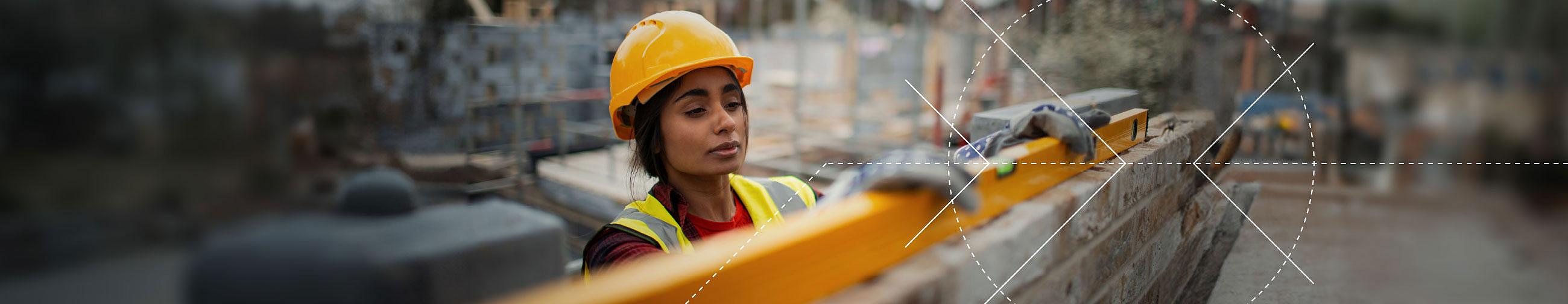  Female worker wearing a yellow safety helmet on a large construction site