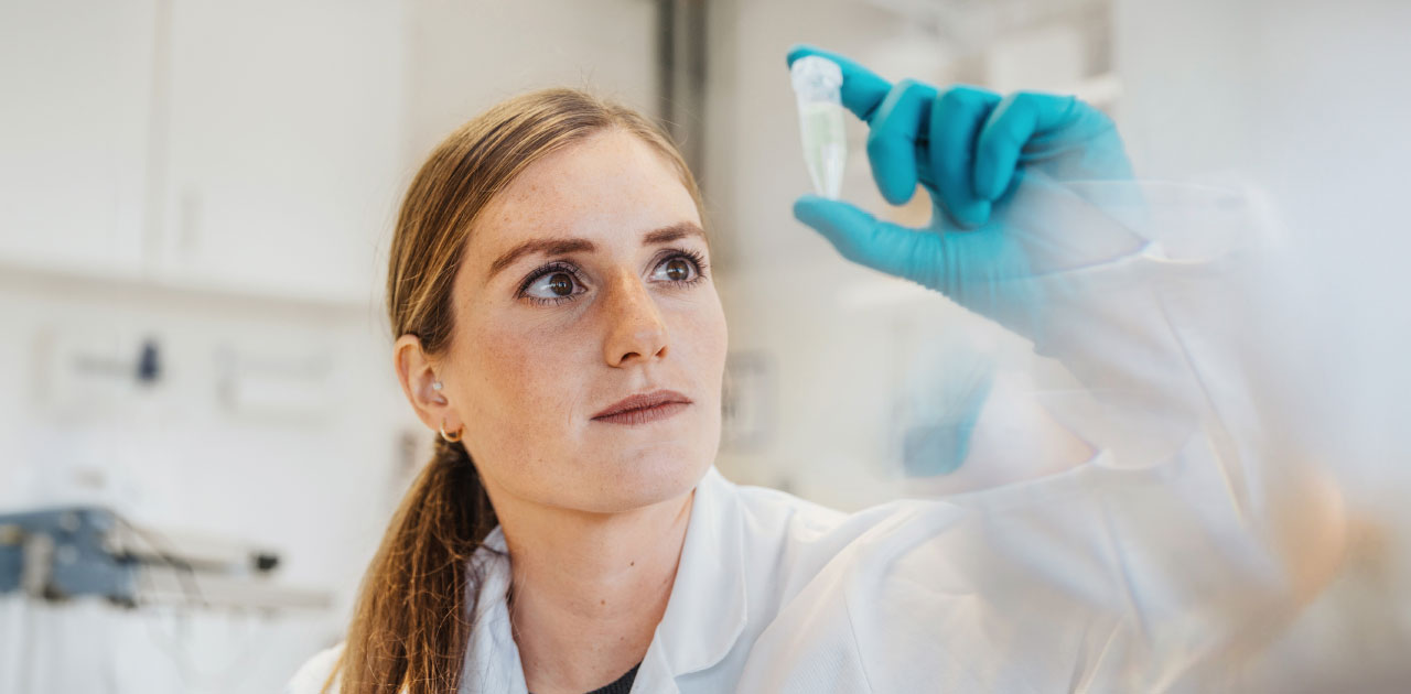 Young woman in the laboratory examining a test vessel