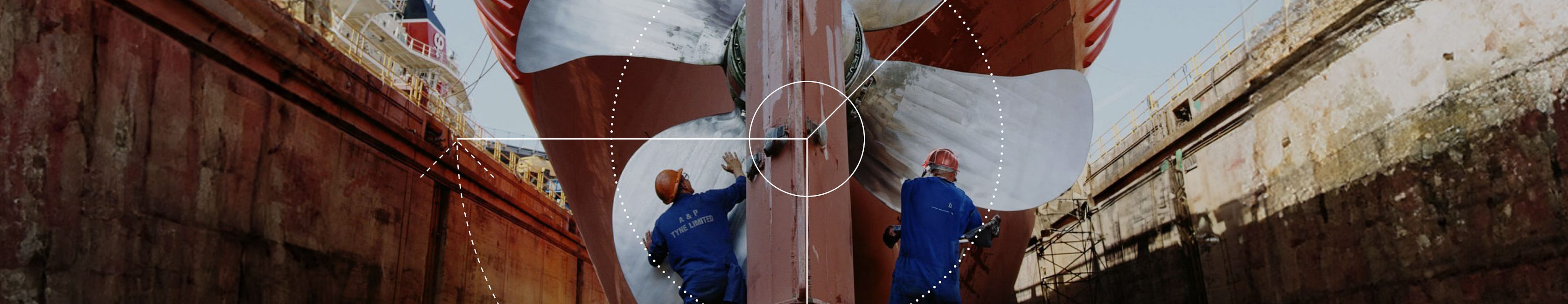 Two workers working on a large ship's propeller