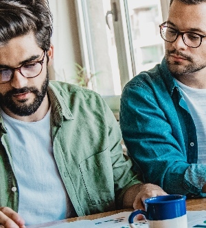 Imagen de dos amigos mirando unas notas