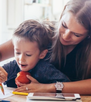 Imagen de una madre enseñando a su hijo a escribir