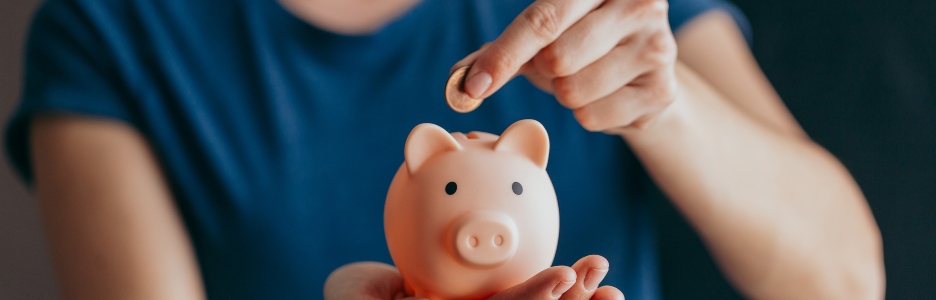 Imagen de una mujer ahorrando, metiendo monedas en su hucha