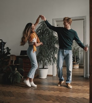 Imagen de longitud total de una pareja joven despreocupada bailando juntos en casa.