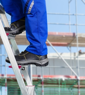 Imagen de un trabajador en la construcción bajando de una escalera