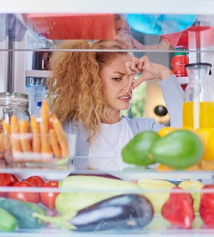 Imagen de una mujer que encuentra su nevera con comida caducara