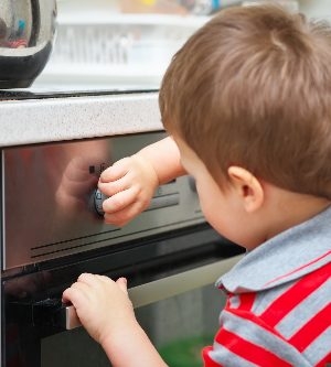 Imagen de un niño en la cocina encendiendo el horno sin supervisión de sus padres
