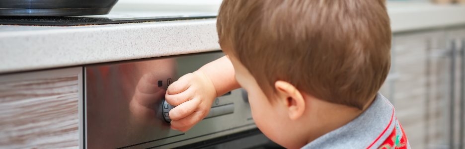 Imagen de un niño en la cocina encendiendo el horno sin supervisión de sus padres