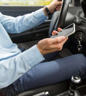 Imagen de una persona con el móvil en la mano en su coche
