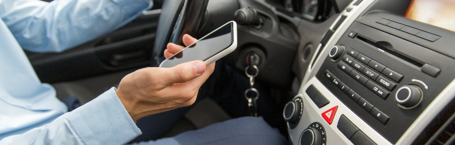 Imagen de una persona con el móvil en la mano en su coche