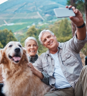 Imagen de un perro y dos adultos haciendo un selfie todos juntos
