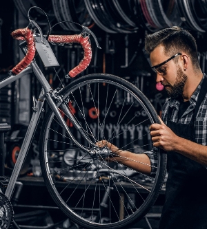 Imagen de un hombre arreglando una bicicleta en un taller