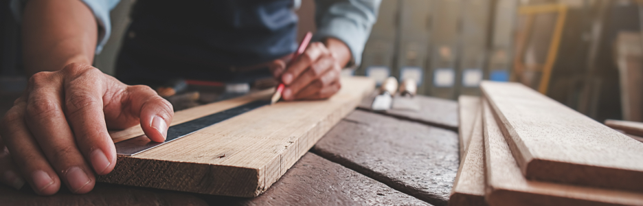 Imagen de una persona midiendo una tabla de madera