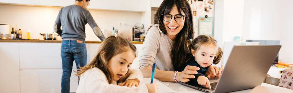 Imagen de una familia en el salón - comedor mientras la madre teletrabaja