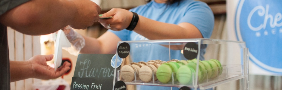 Imagen de una vendedora de macarons francés atendiendo a un cliente