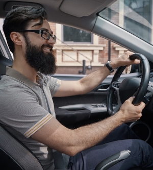 Imagen de un hombre joven conduciendo su coche