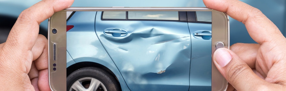 Imagen de una persona haciendo una foto con su móvil de su coche para cobrar una indemnización