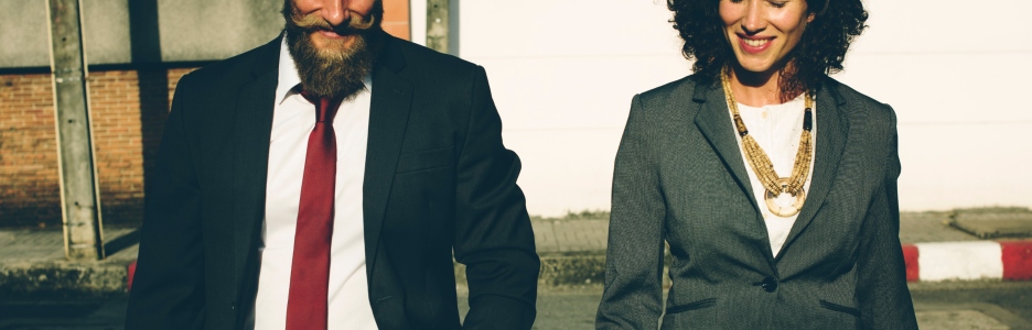 Imagen de dos profesionales en traje caminando juntos