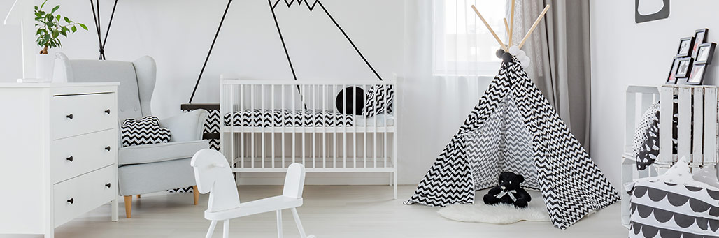 Imagen de una habitación de un bebé con su cuna y un tipi