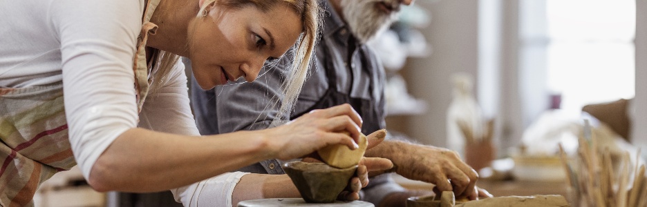 Imagen de manos artesanos haciendo tazas de arcillas rojas