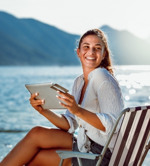 Imagen de una mujer sonriendo haciendo una compra online con su tarjeta bancaria