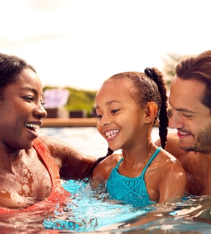 Imagen de una familia refrescándose en una piscina comunitaria