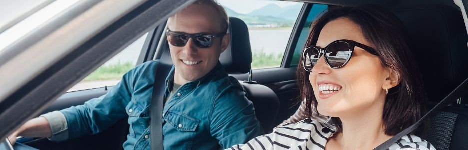 Imagen de una mujer conduciendo su coche mientras el pasajero habla con ella