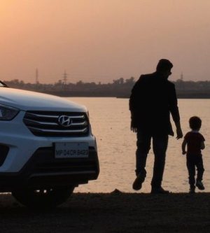 Imagen de un padre con su hijo en el puerto con el coche aparcado
