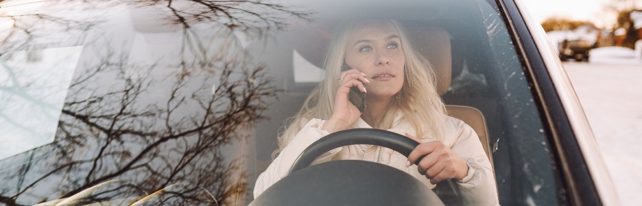 Imagen de una mujer conduciendo su coche sospechando la presencia del uso de drones de la DGT