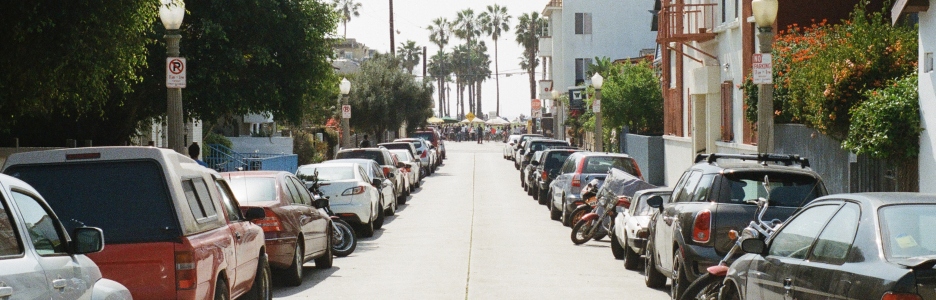 Imagen de coches y motos aparcados en una calle