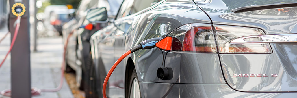 Imagen de un coche eléctrico cargando en la calle