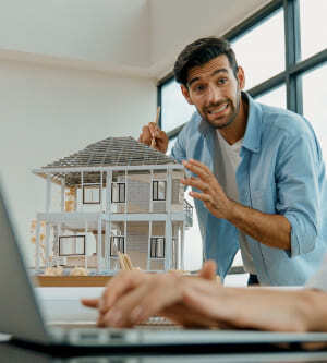 Imagen de un hombre enseñando modelo de una vivienda sostenible 