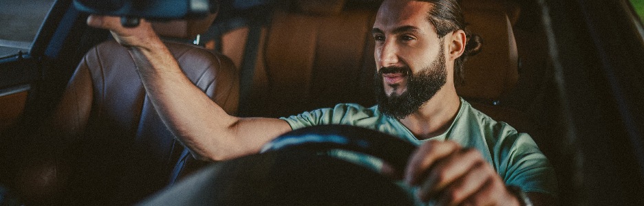 Imagen de hombre moreno hermoso joven que conduce un coche