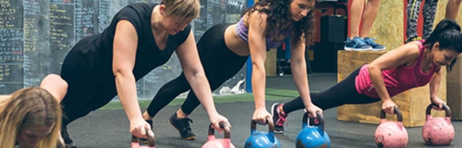 Imagen de personas haciendo flexiones de brazo sobre kettlebell