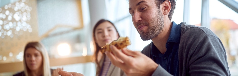 Imagen de jóvenes empresarios comiendo durante un almuerzo en un ambiente agradable en el edificio de la empresa.